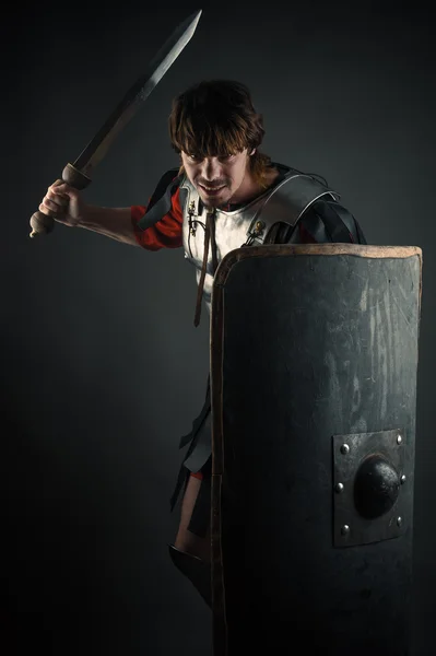 Jeune guerrier avec une épée et un bouclier à la main — Photo