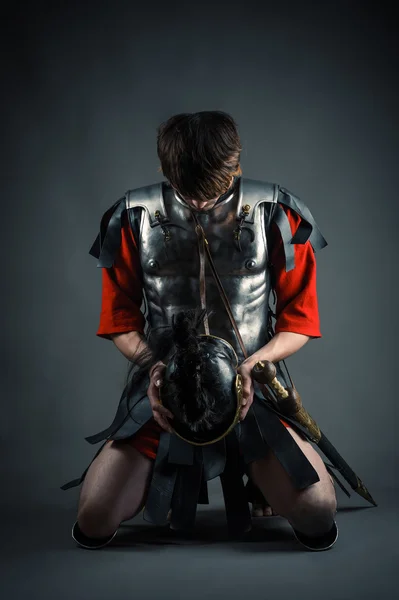 Homme agenouillé avec un casque dans les mains — Photo