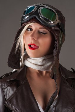 woman in aviator helmet winks and licking lips