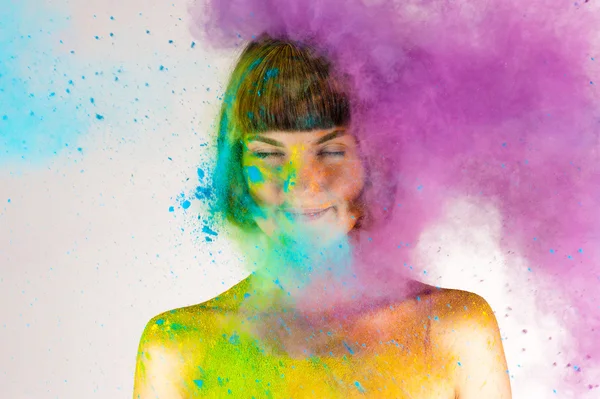 Beautiful brunette girl in colors Holi on a white — Stock Photo, Image