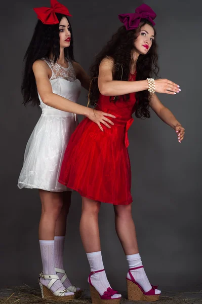 Two beautiful fashion dolls isolated on a gray background — Zdjęcie stockowe