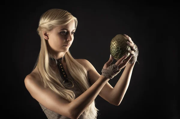 Привлекательная женщина в платье с драконьим яйцом в руках — стоковое фото