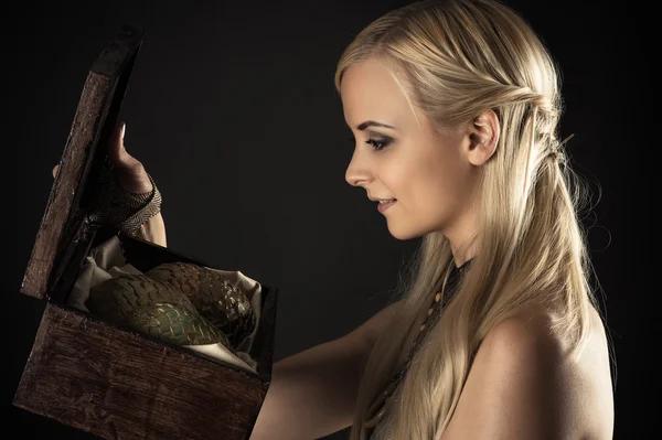 Blond woman holding a box with eggs dragons — Stock Photo, Image