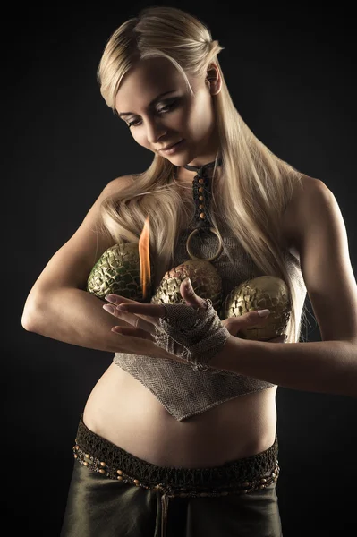 Beautiful woman warms fire dragon eggs — Stock Photo, Image