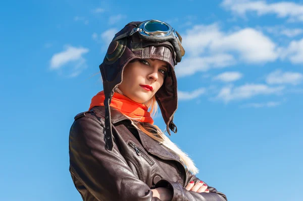 Mooie vrouw in vlieger helm op de hemelachtergrond — Stockfoto