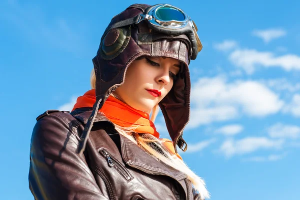 Sorg kvinna i aviator hjälm på himmel bakgrund — Stockfoto