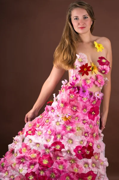 Красивая женщина в платье из цветов изолированы на коричневый — стоковое фото