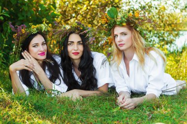 üç sevimli kadın çim üzerinde yalan