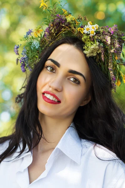 Bela mulher morena com uma coroa de flores na cabeça — Fotografia de Stock