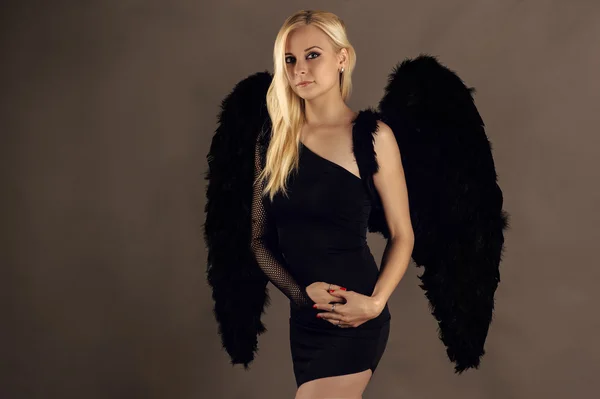 Blond woman with black angel wings — Stock Photo, Image