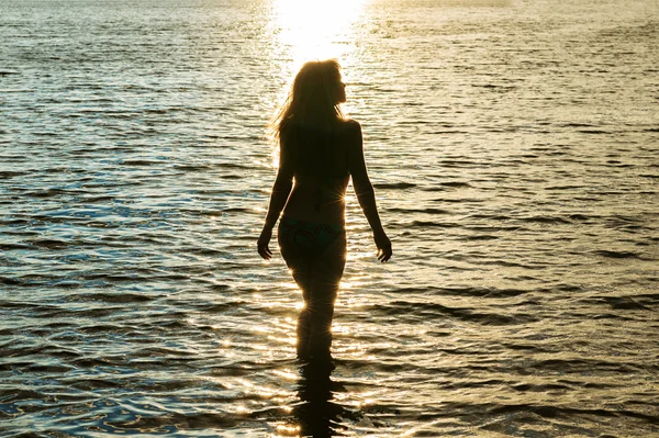 Silhouette woman at sunset in water Stock Photo