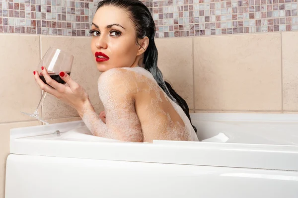 Donna nuda in un bagno con un bicchiere di vino — Foto Stock