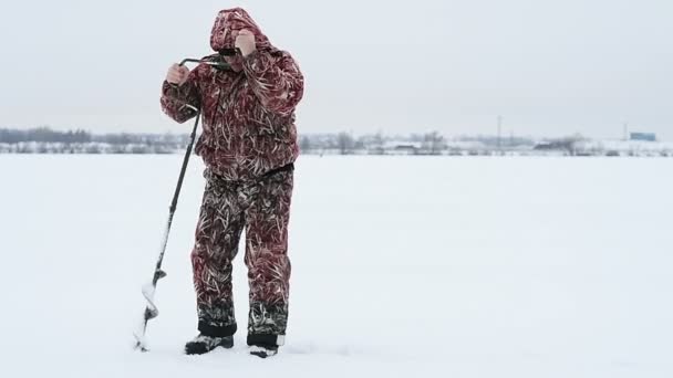 Homme faisant trou pour la pêche — Video