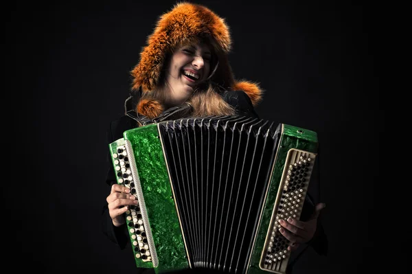 Emotional woman in fur hat playing the accordion — Stock Photo, Image