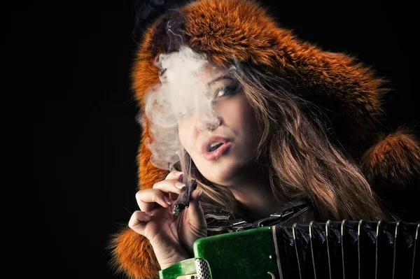 Atraktivní žena v kožešinové kloboukem v cigaretovém kouři — Stock fotografie