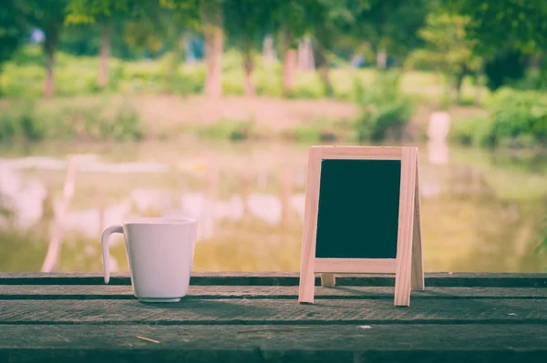 Petit tableau noir sur table en bois rustique — Photo