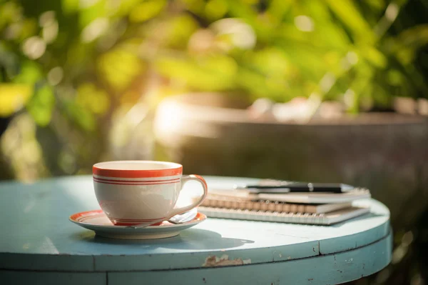 Koffiekopje met laptop op café tafel — Stockfoto