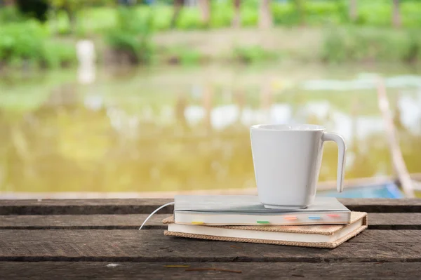咖啡杯与质朴的木桌上的笔记本 — 图库照片