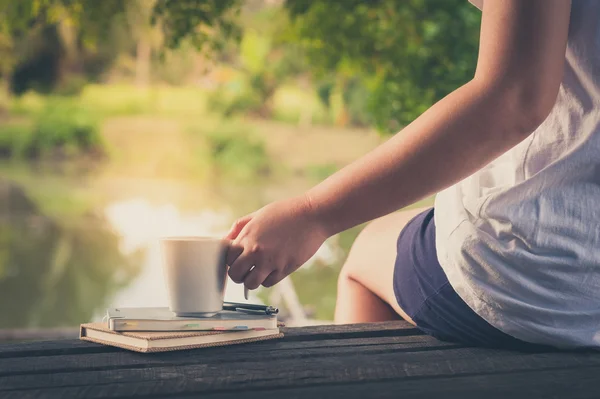 Coffee cup with notebook on rustic wood table — Stock Photo, Image