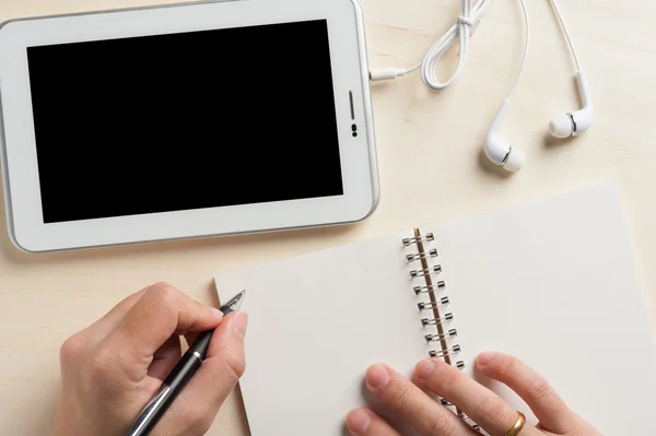 Menulis di notebook dengan tablet kecil — Stok Foto