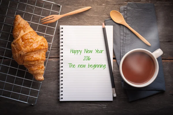 Notebook with message and croissant — 图库照片