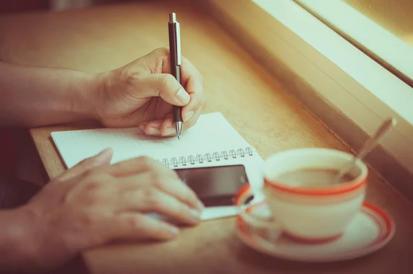 Escribir en el cuaderno con taza de café — Foto de Stock