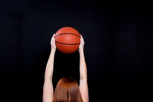 Woman holding a basketball in the air. — Stock Photo, Image