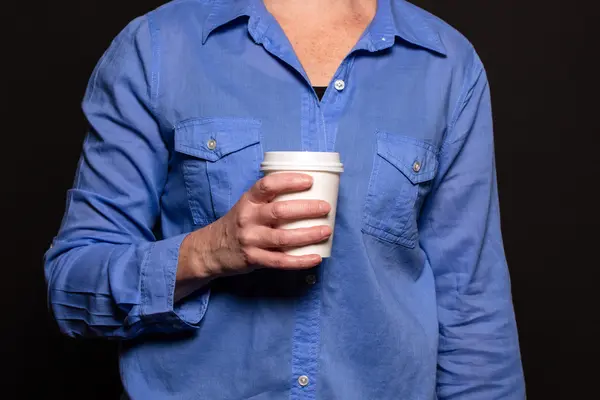 Mujer con camisa azul sosteniendo una taza de café con una mano —  Fotos de Stock