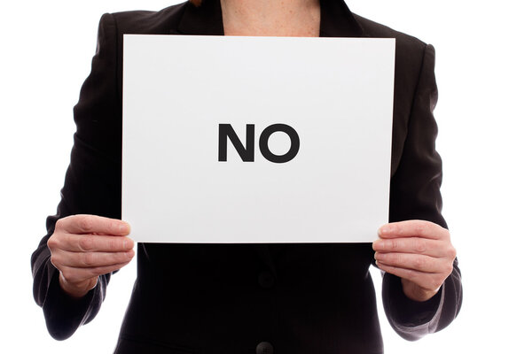 Woman in a business suit holding a piece of paper saying "No".