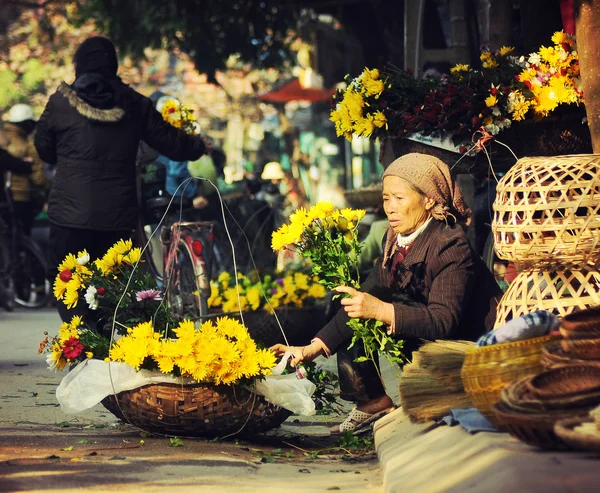 Неизвестный поставщик флористов на небольшом рынке 21 апреля 2014 года в Ханое, Вьетнам . Стоковое Изображение
