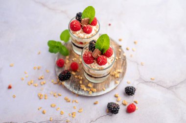 Cam kavanozlarda Yunan yoğurdu ahududu parfümleri, küçük sağlıklı tatlı.