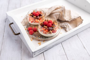 Cam kavanozlarda Yunan yoğurdu ahududu parfümleri, küçük sağlıklı tatlı.