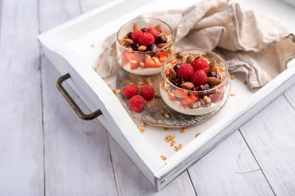 Cam kavanozlarda Yunan yoğurdu ahududu parfümleri, küçük sağlıklı tatlı.