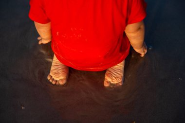 Baby feet on the beach in the sand during vacation