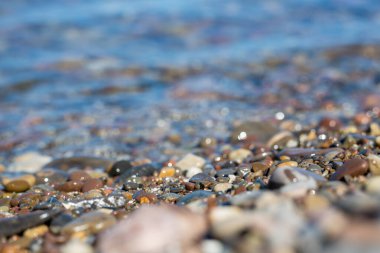 Lake Ontario shoreline with colorful stones and crystal clear freshwater.