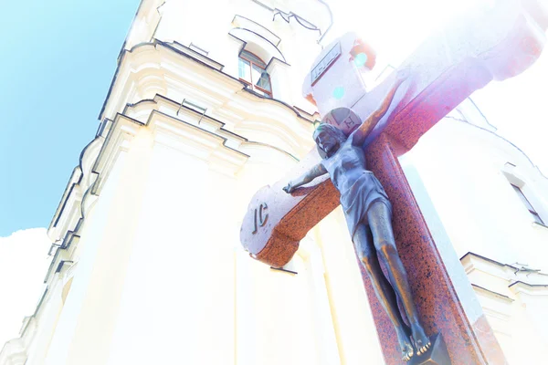 Jesus på träkors i en bakgrund av kyrkan med glimt solsken — Stockfoto