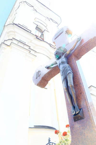 Jesús en la cruz de madera en un fondo de iglesia con la luz del sol vislumbre — Foto de Stock