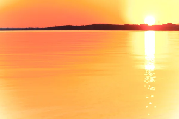 Вечірній захід сонця з красивими відблисками сонця на воді — стокове фото