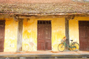 Vietnam, geleneksel çatı ile sarı evin yanında yeşil Bisiklet