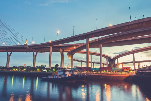 Boot auf dem Fluss mit Bhumibol-Brücke Hintergrund in der Dämmerung. — Stockfoto