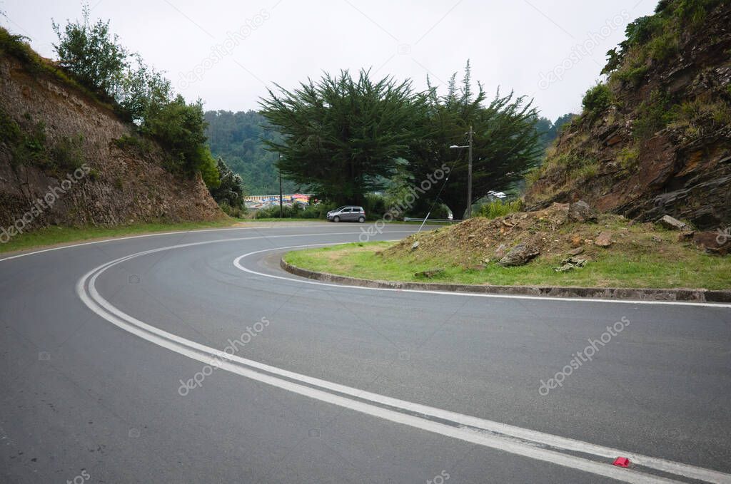 Empty curved road in small village on the Pacific Coast of Chile. Bahia Mansa, Chile.