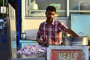 Kanyakumari, Tamil Nadu, Hindistan - Şubat 2017: Hintli adam sokağın üzerindeki küçük kafede soğan doğruyor