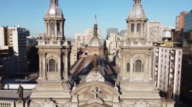 Santiago Metropolitan Katedrali insansız hava aracı görüntüsü. Şehrin ufuk çizgisi insansız hava aracı görüntüleri. İki kulenin arasından uç ve Bakire Meryem heykelinin üzerinden geç. Santiago, Şili