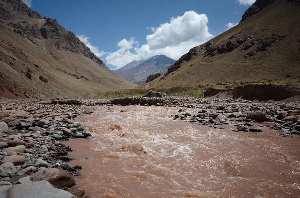 And Dağları 'ndaki Aconcagua Ulusal Parkı' ndaki Horcones Nehri deresi. Bulutlardaki Aconcagua zirvesine bakın. Mendoza Eyaleti, Arjantin.