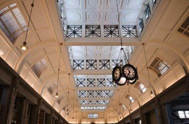 Etiro Mitre tren istasyonunun içi. Tren istasyonunun beyaz tavanının arka planında güzel bir klasik istasyon saati var. Buenos Aires 'teki Retiro Mitre istasyonunun içine bak