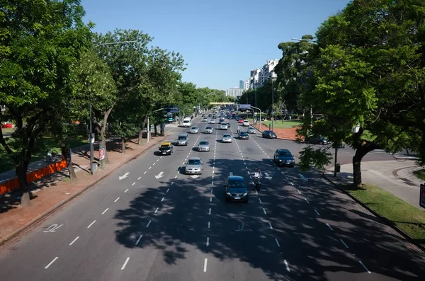 Buenos Aires, Arjantin - Ocak 2020 Avenida Presidente Figueroa Alcorta denen tek yönlü cadde. Başkentte trafik var. Yeşil ağaçlardan oluşan bir ara sokak arasında geniş bir yol var.