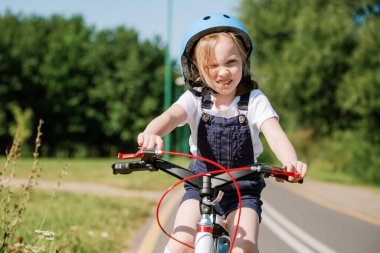 Bisikletli kask takan kız. Bisiklete binen çocuk.