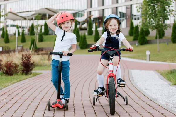 Duas Meninas Divertindo Bicicleta Scooter Irmãs Alegres Capacetes Andando Livre Imagens De Bancos De Imagens Sem Royalties