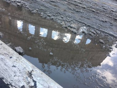 Roma 'daki kar yağışından sonra Colosseum' un su birikintisinde yansıması. 