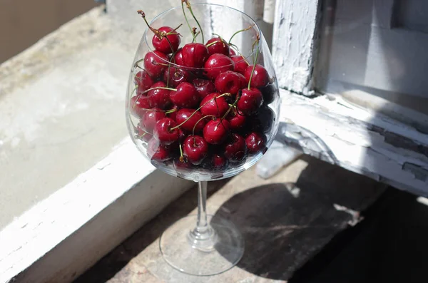 Glass Wine Goblet Filled Lots Cherries Standing Windowsill Blurred Light — Stock Photo, Image